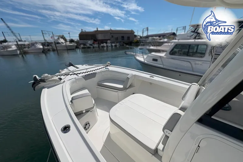 Slide: The Image of 2023 Parker 2400 Center Console boat docked at marina under clear blue sky. - 3