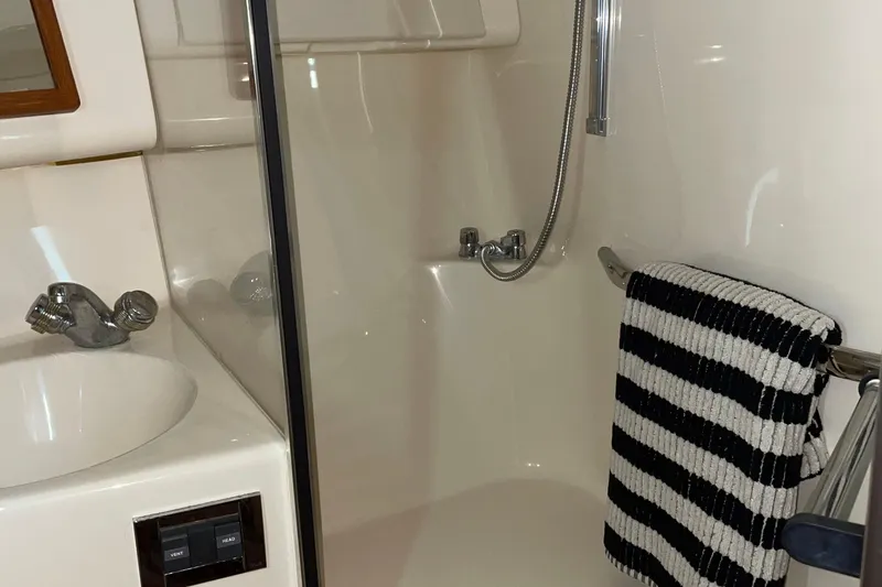 Slide: The Image of Bathroom interior of 2000 Sea Ray 400 Sedan Bridge yacht, featuring sink and shower. - 19