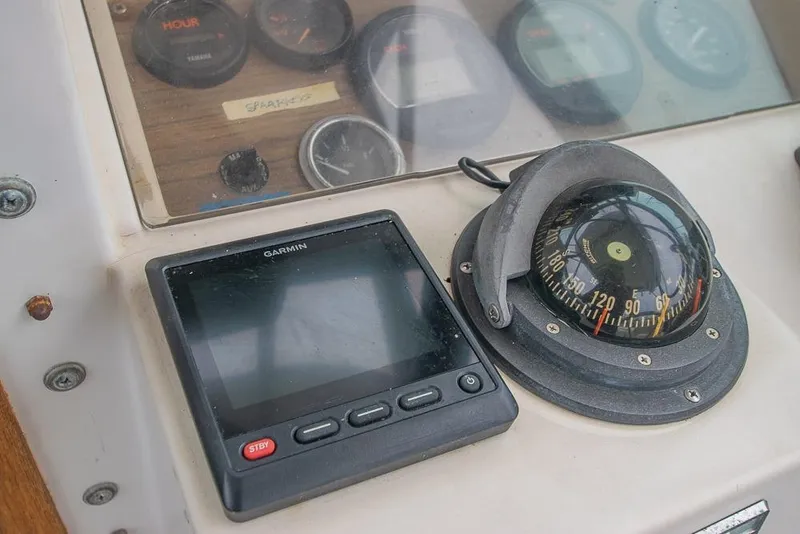 Slide: The Image of 1990 Grady White SEAFARER dashboard with Garmin device and compass. - 12