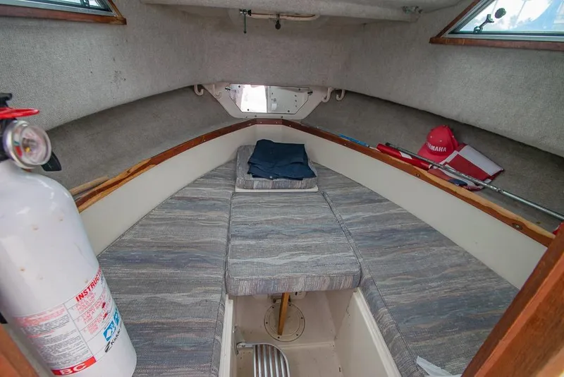 Slide: The Image of 1990 Grady White SEAFARER cabin interior with fire extinguisher and seating area. - 14