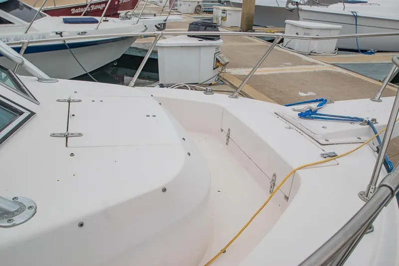 Slide: The Image of 1990 Grady White SEAFARER boat docked, showcasing deck and railing details. - 19
