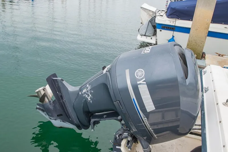 Slide: The Image of 1990 Grady White SEAFARER with Yamaha outboard motor docked on calm water. - 22