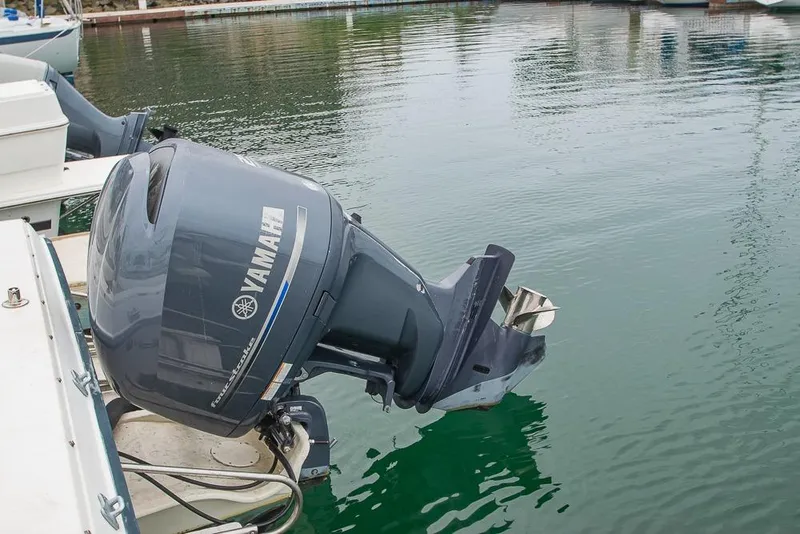 Slide: The Image of 1990 Grady White SEAFARER with Yamaha outboard motor docked in calm waters. - 23