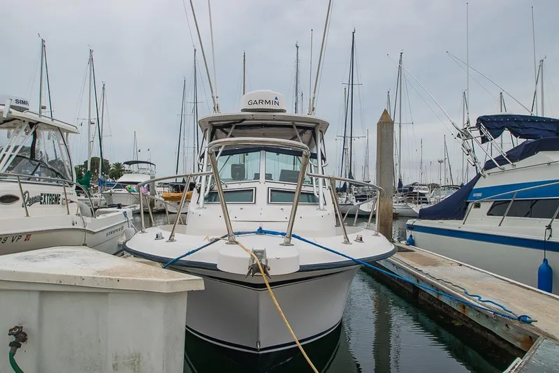 Slide: The Image of 1990 Grady White SEAFARER boat docked at marina, surrounded by other vessels. - 3