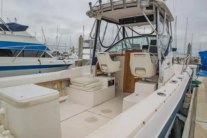 Slide: The Image of 1990 Grady White SEAFARER boat interior at marina, featuring seating and control area. - 5
