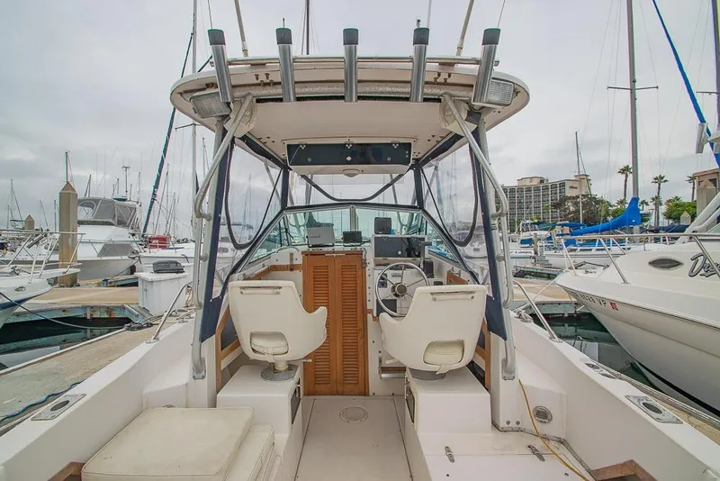Slide: The Image of 1990 Grady White SEAFARER boat interior at marina, featuring helm and seating. - 7