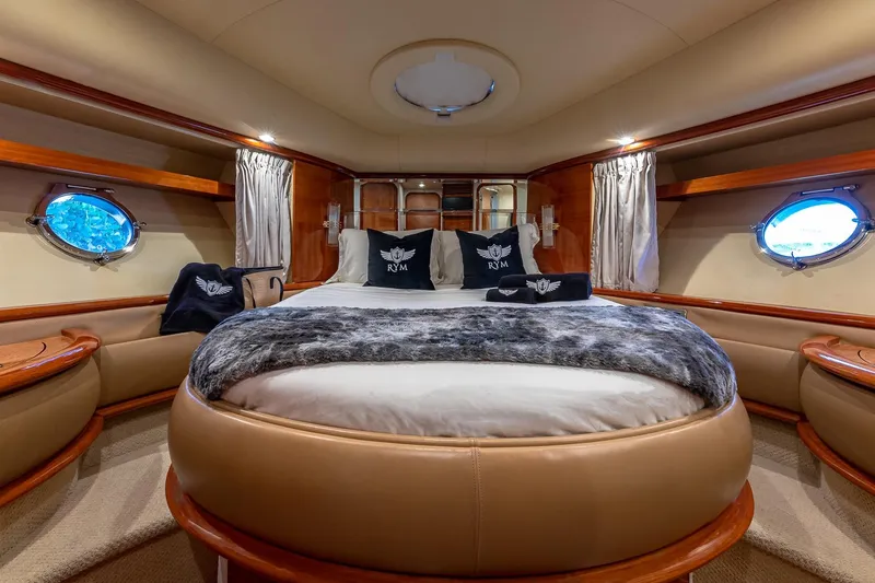 Slide: The Image of Luxurious bedroom interior of 2007 Azimut Fly 62 yacht with elegant decor and porthole windows. - 25