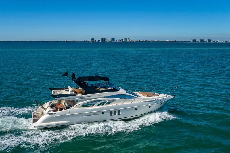 Slide: The Image of 2007 Azimut Fly 62 yacht cruising on open blue water with city skyline backdrop. - 3