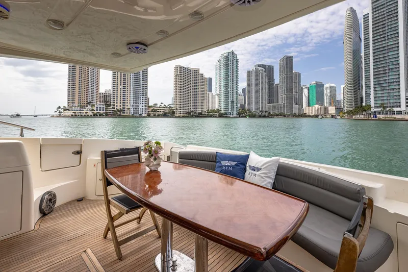 Slide: The Image of 2007 Azimut Fly 62 yacht deck with city skyline view, featuring elegant seating and table. - 9