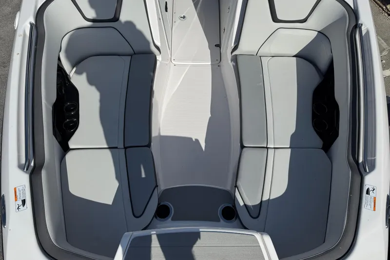 Slide: The Image of 2025 Yamaha Boats AR250 interior seating, featuring sleek gray upholstery and cup holders. - 11