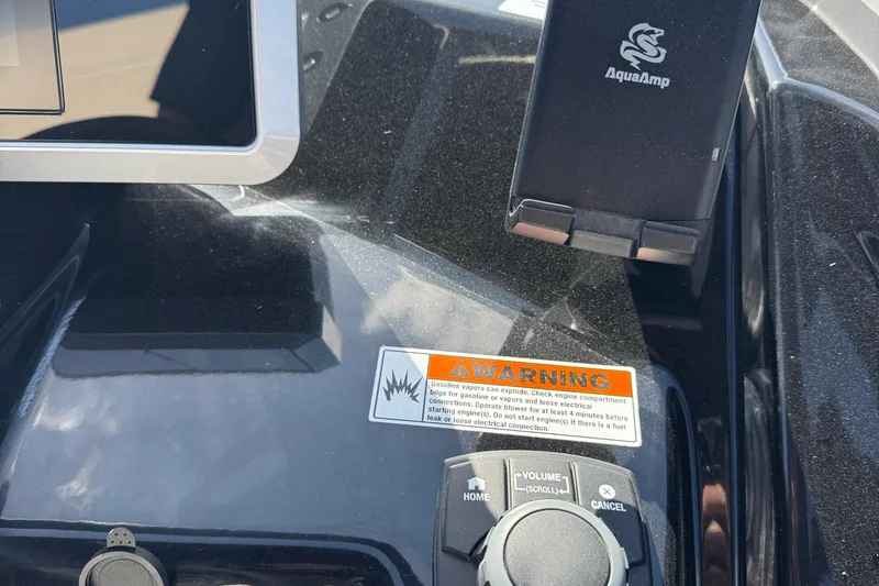 Slide: The Image of Control panel of 2025 Yamaha AR250 boat with warning label and AquaAmp holder. - 21