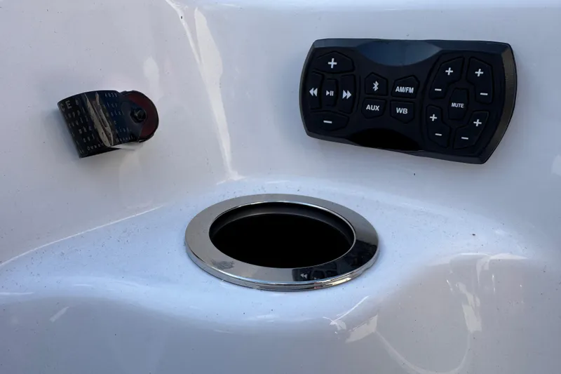 Slide: The Image of 2025 Yamaha Boats AR250 control panel with audio system and cup holder. - 25