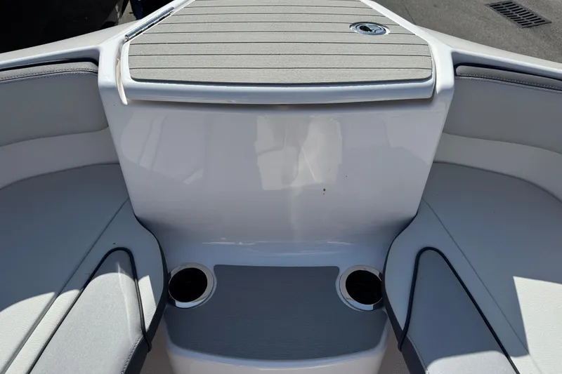 Slide: The Image of 2025 Yamaha Boats AR250 bow seating area with cup holders and sleek design. - 9