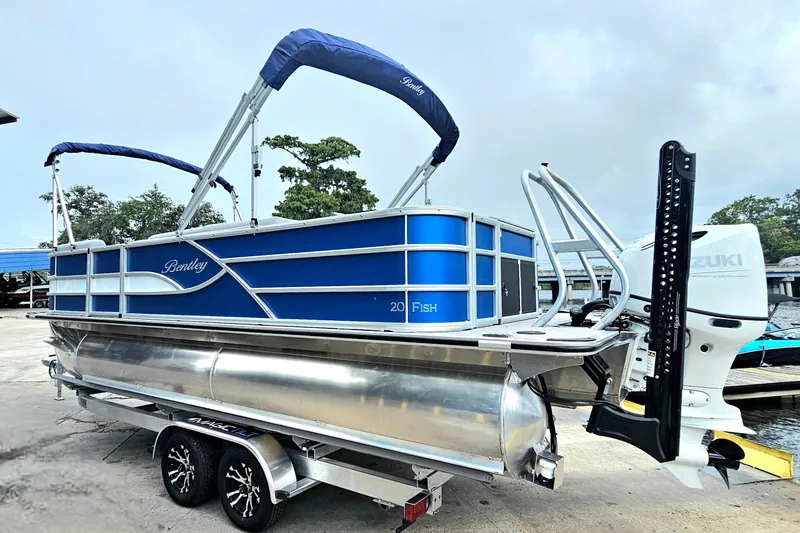Slide: The Image of 2026 Bentley Pontoons 203 Fish-N-Cruise boat with Suzuki engine, docked on trailer. - 3