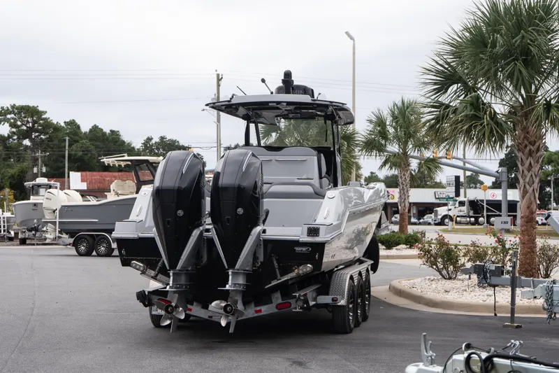 Slide: The Image of 2024 Sunsation 32 CCX boat on trailer, dual engines, parked near palm trees. - 7