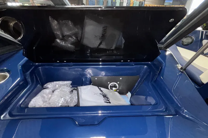 Slide: The Image of 2026 ATX Surf Boats 24 Type-S storage compartment with bubble wrap and accessories. - 16