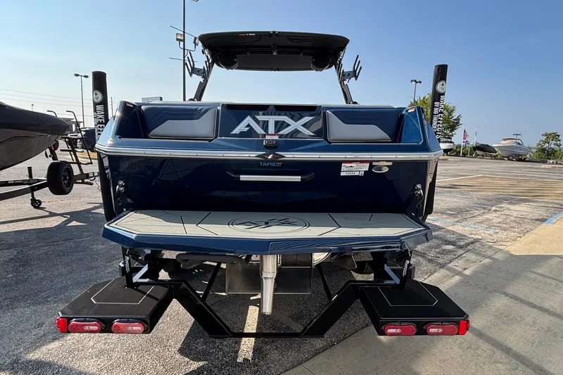 Slide: The Image of 2026 ATX Surf Boats 24 Type-S, rear view in parking lot, showcasing sleek design. - 4