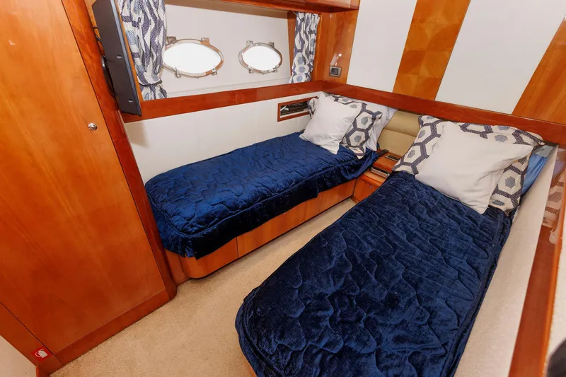 Slide: The Image of Luxurious twin cabin in 2005 Aicon Yachts 56 Flybridge with blue bedding and wooden accents. - 54