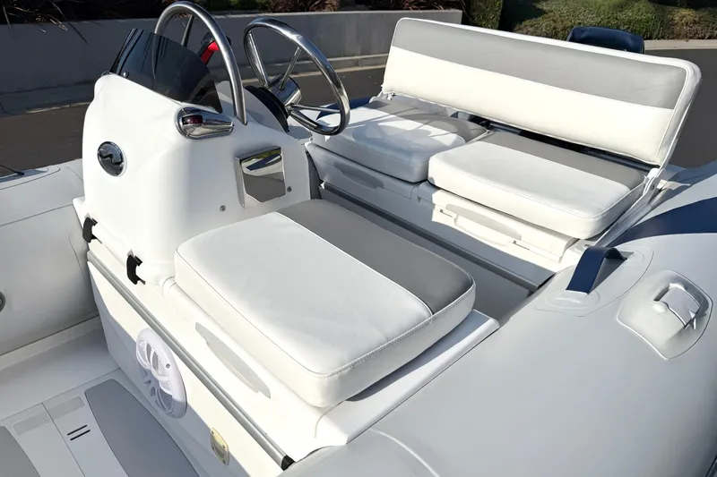 Slide: The Image of 2015 Walker Bay Genisis 310 boat interior with white cushioned seating and steering console. - 20