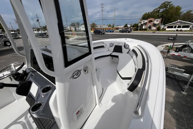 Slide: The Image of 2026 Tidewater 220 LXF boat interior with seating and console, parked near a road. - 13
