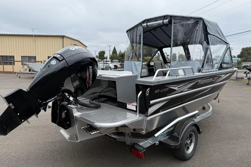 Slide: The Image of 2026 Thunder Jet 185 Luxor boat with Mercury outboard motor, parked on a trailer. - 2