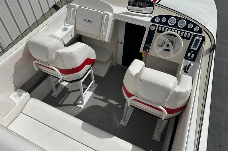 Slide: The Image of 1998 Velocity 26 Thoroughbred boat interior with white and red seating, steering wheel, and dashboard. - 12