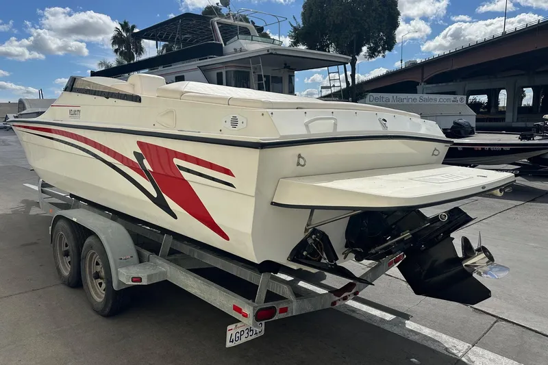 Slide: The Image of 1998 Velocity 26 Thoroughbred boat on trailer, featuring sleek design and vibrant graphics. - 6