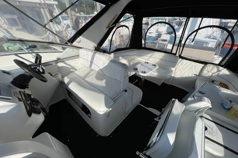 Slide: The Image of Interior of a 2001 Larson Cabrio 330 boat with white seating and steering area. - 3