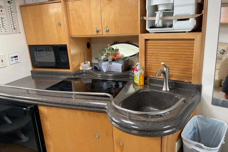 Slide: The Image of 2001 Larson Cabrio 330 boat kitchen with sink, microwave, and coffee maker. - 4