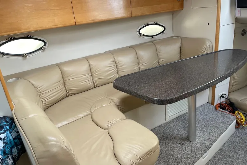 Slide: The Image of Interior of 2001 Larson Cabrio 330 with beige leather seating and oval table. - 5