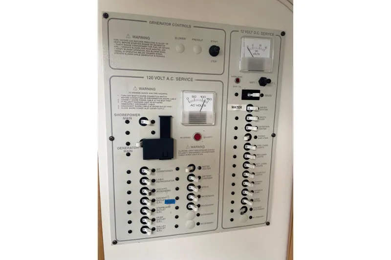 Slide: The Image of Electrical control panel of a 2001 Larson Cabrio 330 boat, featuring generator and voltage meters. - 9