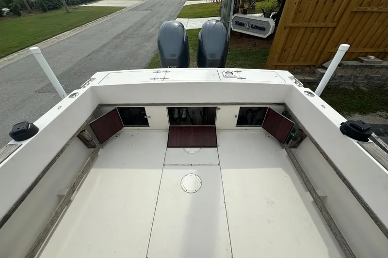Slide: The Image of 1987 Grady-White Gulfstream 232 boat deck with storage compartments and dual engines. - 13