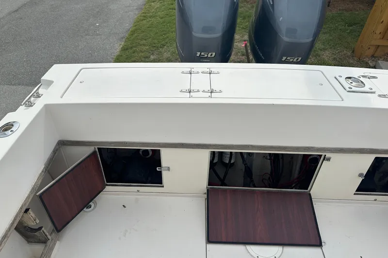 Slide: The Image of 1987 Grady-White Gulfstream 232 boat deck with open storage compartments and twin 150 engines. - 16