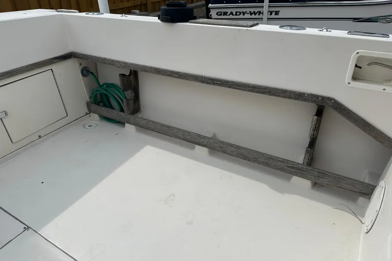 Slide: The Image of 1987 Grady-White Gulfstream 232 boat interior with storage compartment and hose. - 21