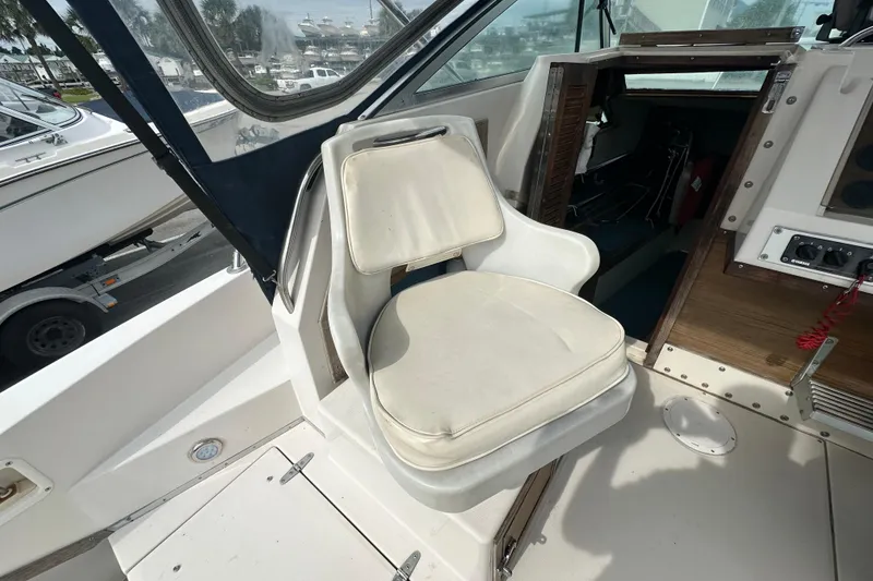 Slide: The Image of 1987 Grady-White Gulfstream 232 boat interior with white captain's chair and cabin entrance. - 25