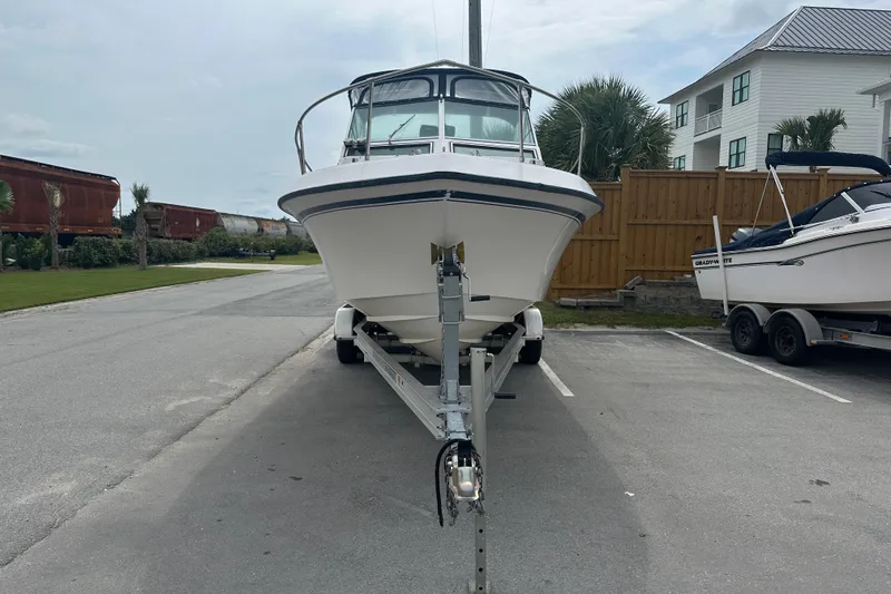 Slide: The Image of 1987 Grady-White Gulfstream 232 boat on trailer, parked in a lot near buildings. - 3