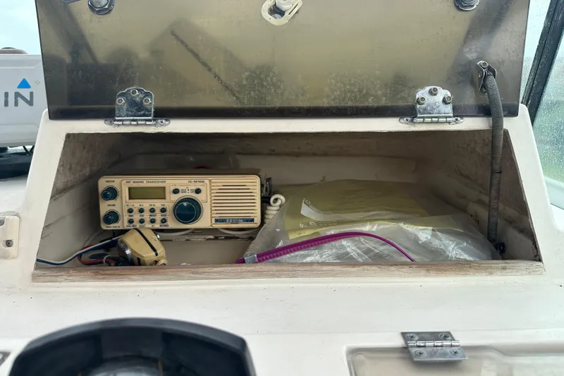Slide: The Image of 1987 Grady-White Gulfstream 232 boat compartment with marine radio and storage items. - 34