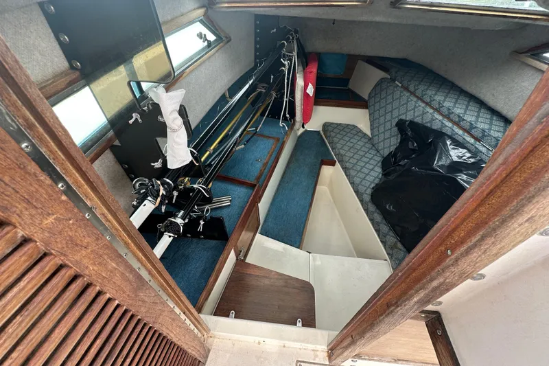 Slide: The Image of 1987 Grady-White Gulfstream 232 cabin interior with fishing rods and seating area. - 38