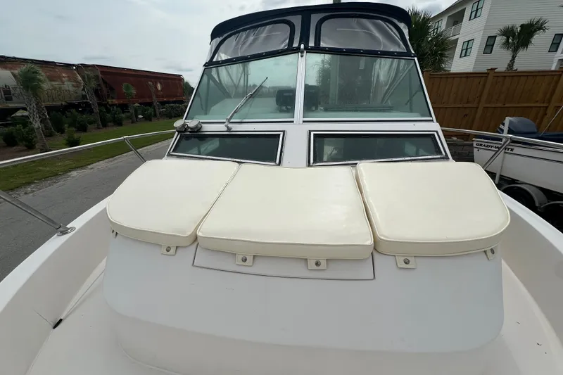 Slide: The Image of 1987 Grady-White Gulfstream 232 boat with cushioned seating and windshield, parked outdoors. - 39