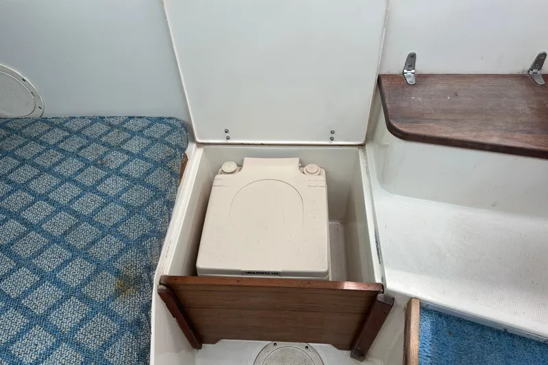 Slide: The Image of 1987 Grady-White Gulfstream 232 boat interior with portable toilet and blue carpet. - 41