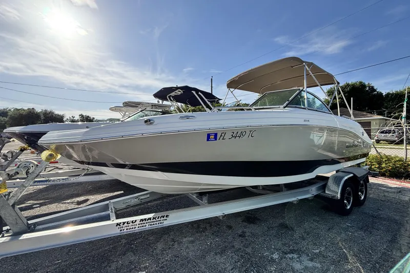 Slide: The Image of 2015 NauticStar 223 DC boat on trailer under sunny sky. - 1