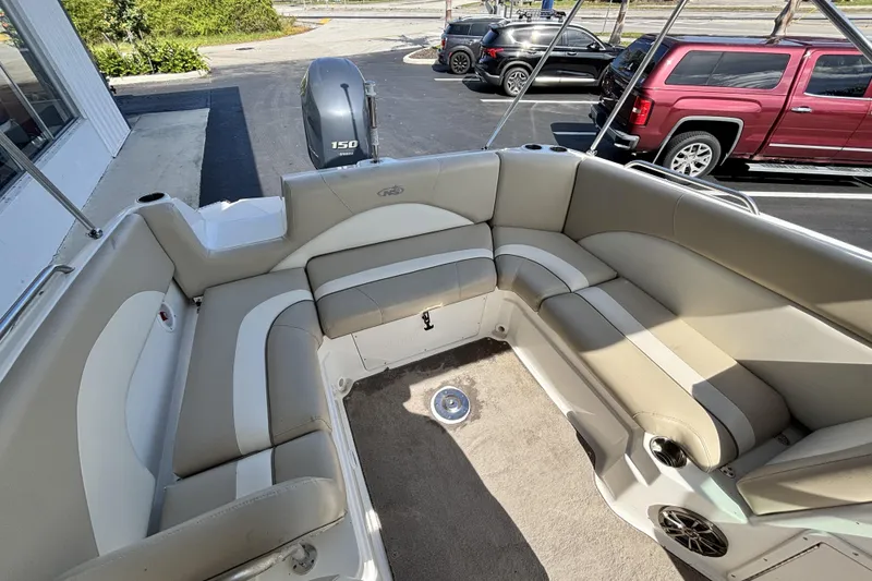 Slide: The Image of 2015 NauticStar 223 DC boat interior with beige seating and a 150 HP engine. - 11