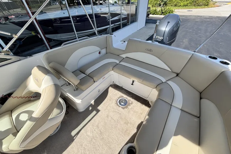 Slide: The Image of 2015 NauticStar 223 DC boat interior with beige seating and a 150 HP outboard motor. - 12