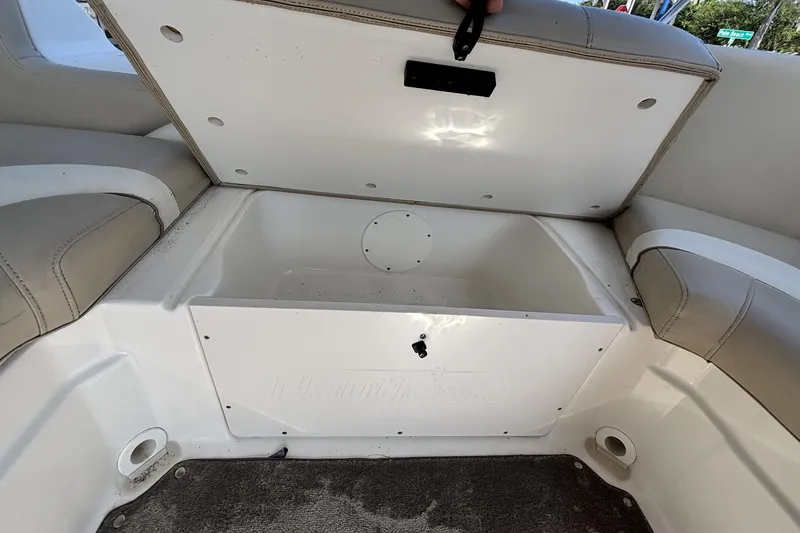 Slide: The Image of Open storage compartment in 2015 NauticStar 223 DC boat with cushioned seating. - 13