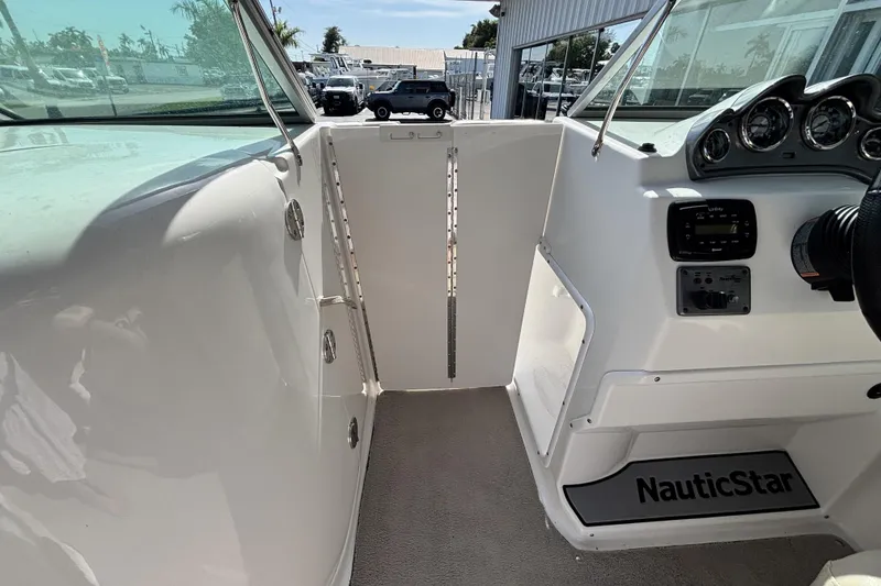 Slide: The Image of Interior view of a 2015 NauticStar 223 DC boat, showcasing dashboard and controls. - 15