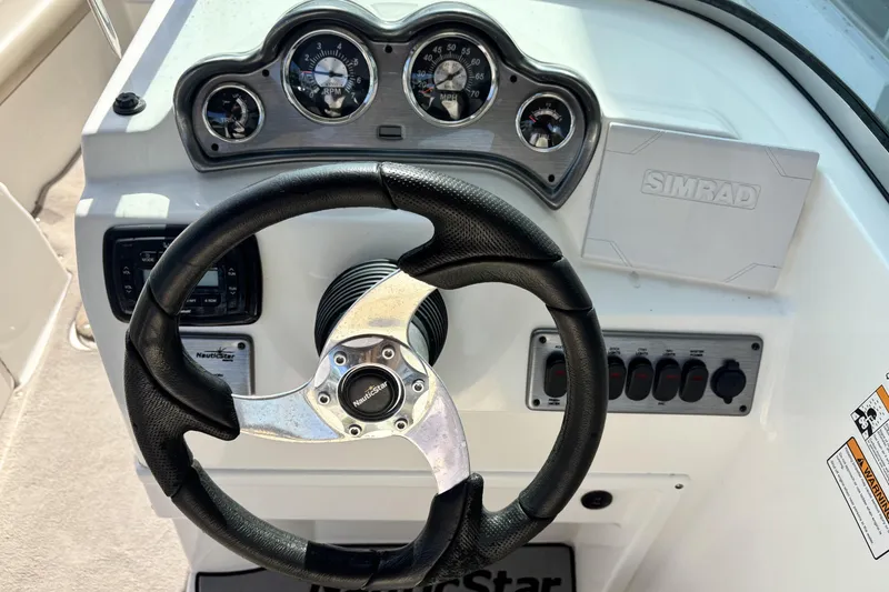 Slide: The Image of Steering wheel and dashboard of 2015 NauticStar 223 DC boat with gauges and controls. - 17