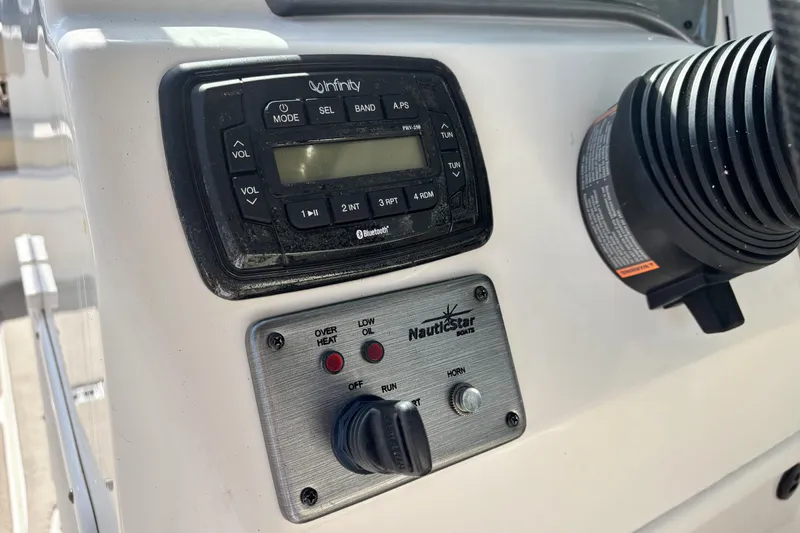 Slide: The Image of Control panel of a 2015 NauticStar 223 DC boat with audio system and switches. - 20