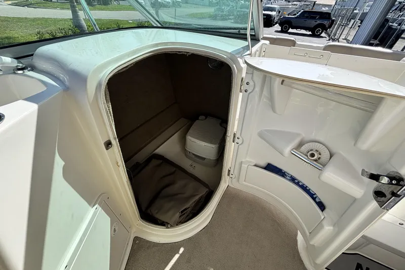 Slide: The Image of 2015 NauticStar 223 DC boat interior storage compartment with portable toilet. - 22