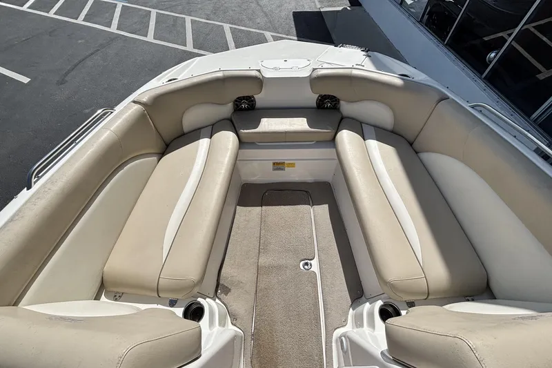 Slide: The Image of 2015 NauticStar 223 DC boat interior with beige seating and carpeted floor. - 25