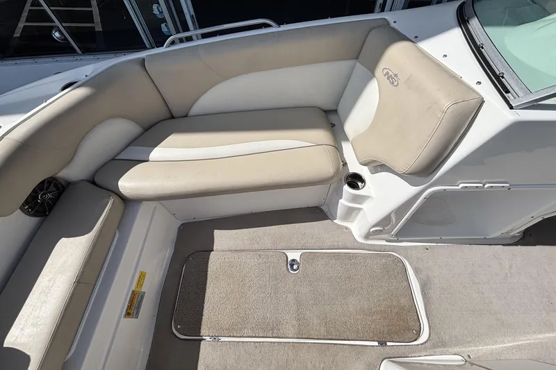 Slide: The Image of 2015 NauticStar 223 DC boat interior with beige seating and carpeted floor. - 26